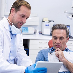 A dentist discussing dental implant treatment with his patient