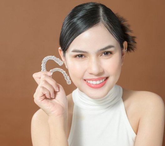 Smiling lady shows off clear aligners