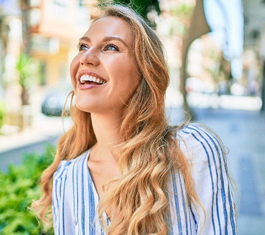Woman with white teeth smiling outside