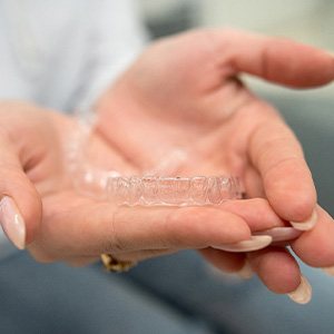 Closeup of patient holding clear aligner