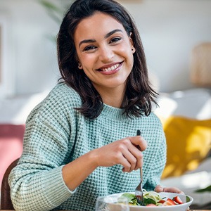 Woman smiling while eating lunch at home