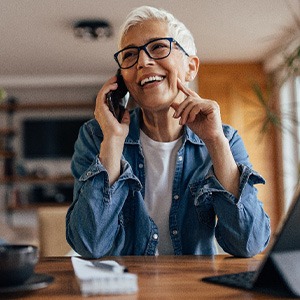 Woman smiling while talking on phone at home