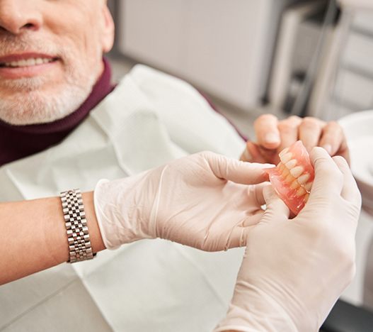 A man discussing dentures with his dentist