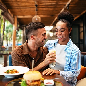 Woman smiling at reflection in handheld mirror