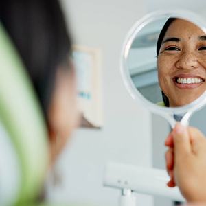 Patient with black glasses smiling in treatment chair