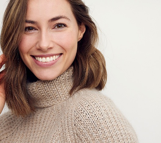 Woman in tan sweater smiling