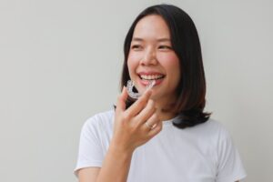 Woman putting on her Invisalign trays